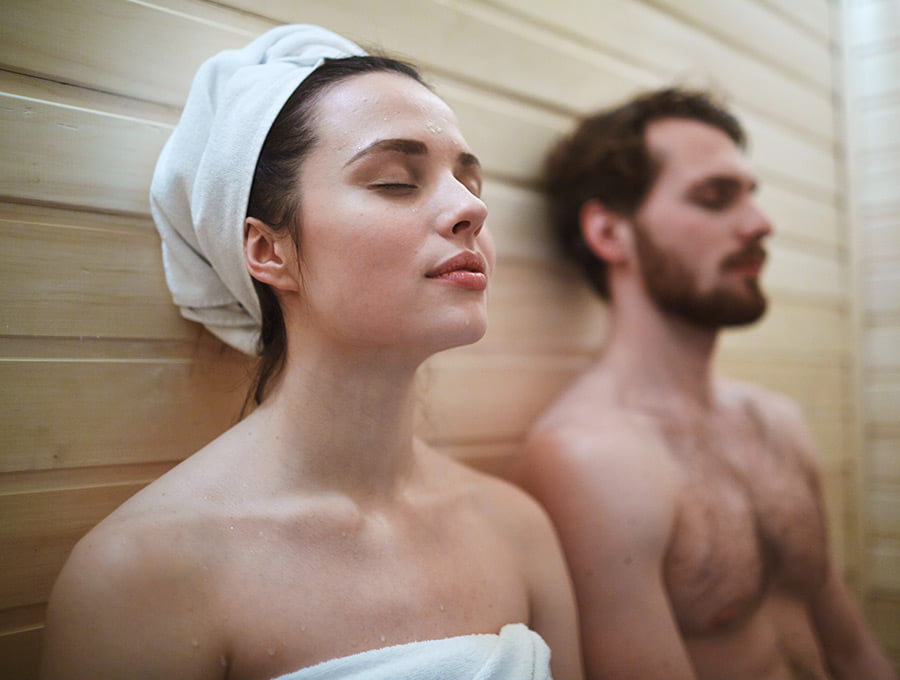 Un hombre y una mujer están dentro de una sauna. Parecen muy relajados.