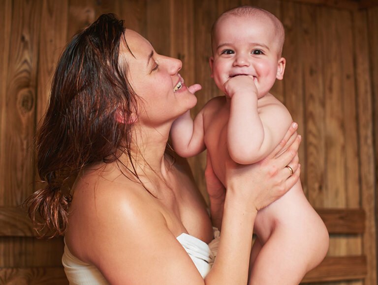 Esta madre está con su bebé dentro de una sauna. La sauna está apagada, así no hay riesgo.