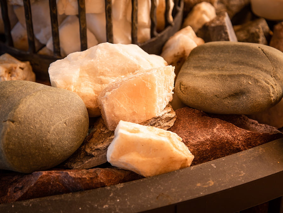 Varias rocas de sal del himalaya junto a las piedras de la sauna.