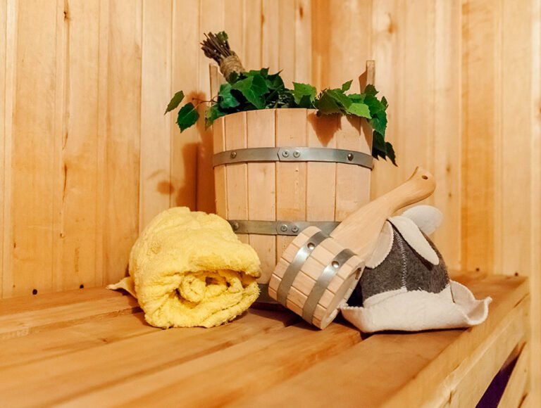 Un cubo de madera, un cazo, una toalla y varias hojas aromáticas para la sauna.